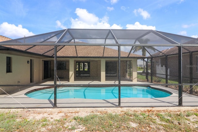 view of swimming pool featuring a patio area and glass enclosure