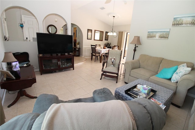 tiled living room featuring vaulted ceiling and a notable chandelier