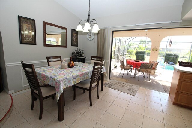 dining area featuring lofted ceiling, a chandelier, and light tile flooring