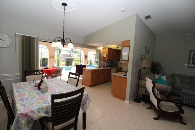 tiled dining room featuring vaulted ceiling and a notable chandelier