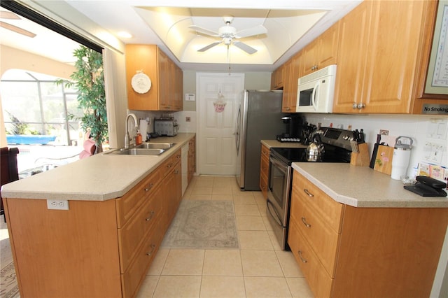 kitchen with ceiling fan, sink, tasteful backsplash, a raised ceiling, and stainless steel electric range oven