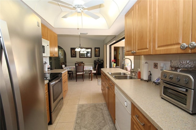 kitchen featuring decorative light fixtures, appliances with stainless steel finishes, ceiling fan with notable chandelier, sink, and light tile floors