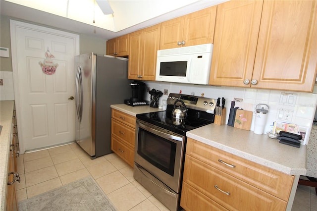 kitchen with light tile flooring, ceiling fan, tasteful backsplash, and stainless steel appliances