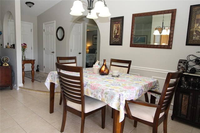 dining space featuring vaulted ceiling, light tile floors, and a chandelier