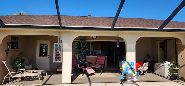 back of property with a patio area and glass enclosure