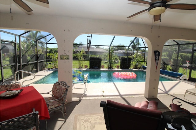 view of pool with glass enclosure and ceiling fan