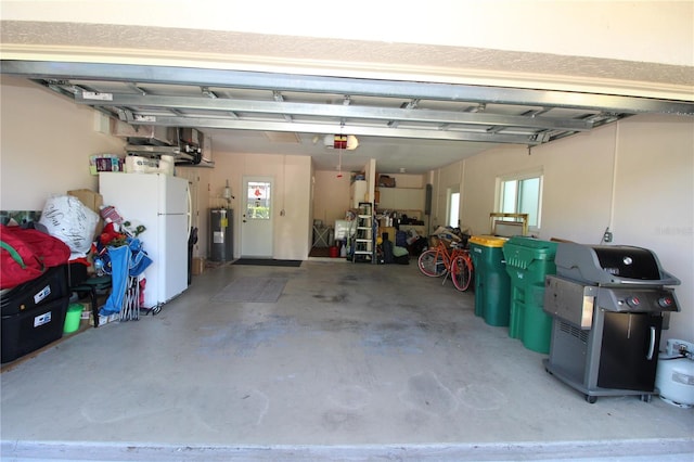 garage featuring white refrigerator, water heater, and a garage door opener