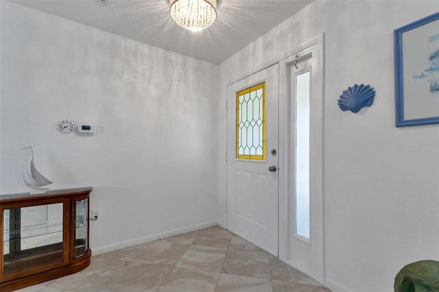 tiled entryway with a notable chandelier and a healthy amount of sunlight