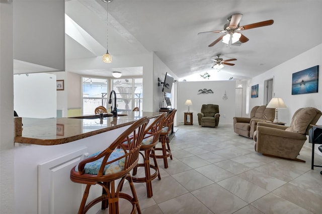 tiled dining room featuring lofted ceiling, sink, and ceiling fan