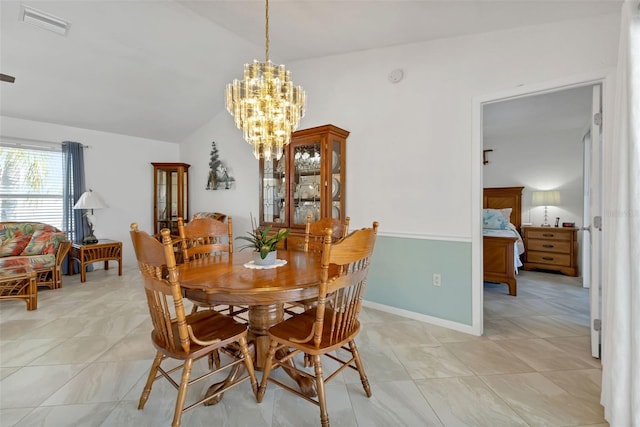 tiled dining room featuring lofted ceiling and a chandelier