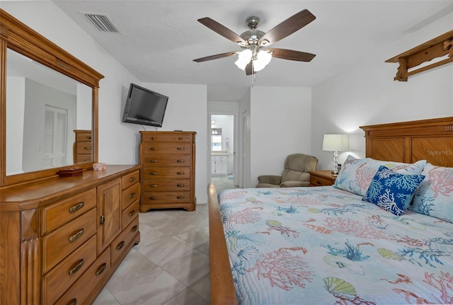 bedroom featuring a closet, ceiling fan, light tile floors, and ensuite bathroom