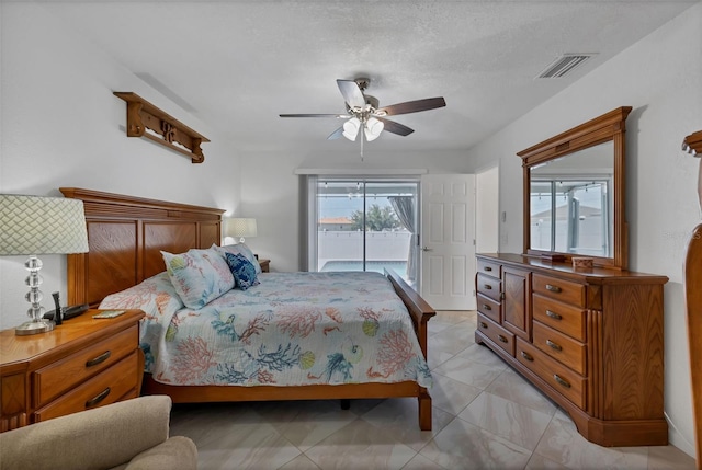 bedroom with ceiling fan, access to outside, a textured ceiling, and light tile flooring