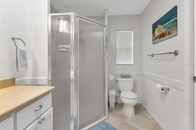 bathroom featuring a shower with shower door, vanity, toilet, and tile flooring