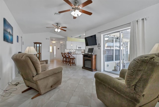 tiled living room with lofted ceiling, a wealth of natural light, ceiling fan, and sink