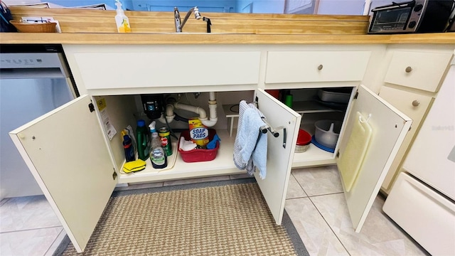 room details featuring wood counters, dishwasher, and sink