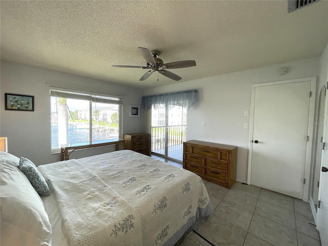 bedroom with access to exterior, a textured ceiling, ceiling fan, and light tile patterned flooring