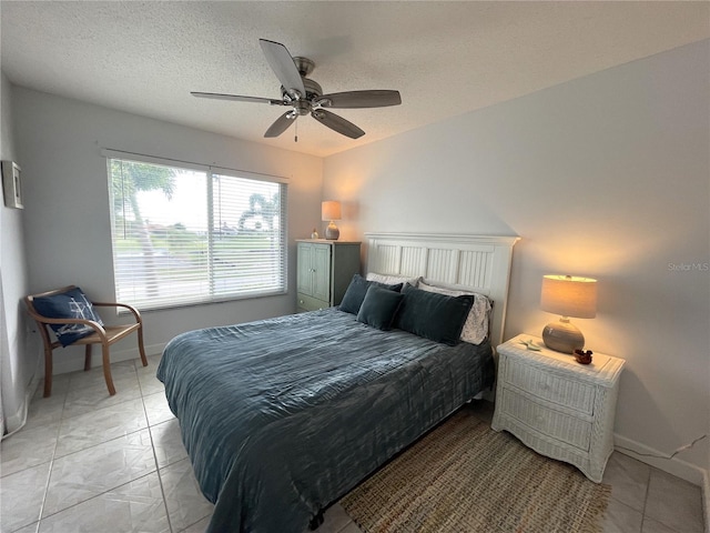 tiled bedroom featuring ceiling fan and a textured ceiling