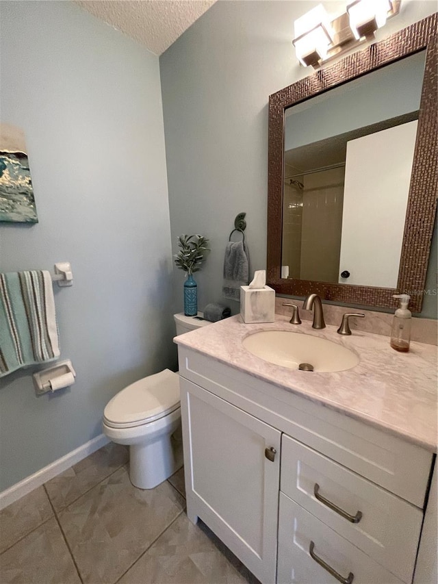 bathroom with vanity, tile patterned flooring, toilet, walk in shower, and a textured ceiling