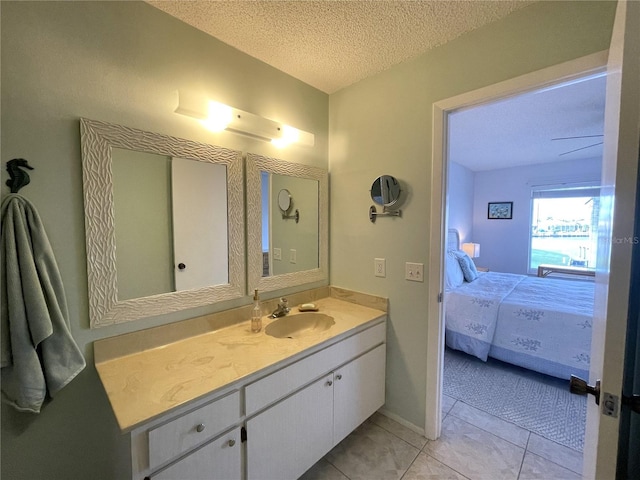 bathroom with tile patterned floors, vanity, and a textured ceiling