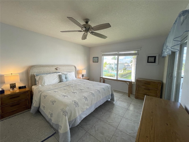 bedroom featuring ceiling fan, a textured ceiling, and light tile patterned floors