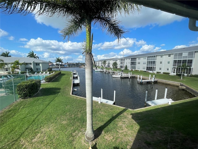 view of dock featuring a lawn and a water view