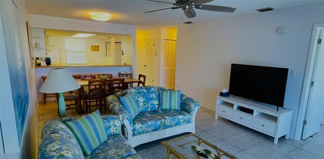 living room featuring light tile patterned floors and ceiling fan