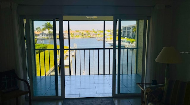 doorway featuring tile patterned flooring, a healthy amount of sunlight, and a water view