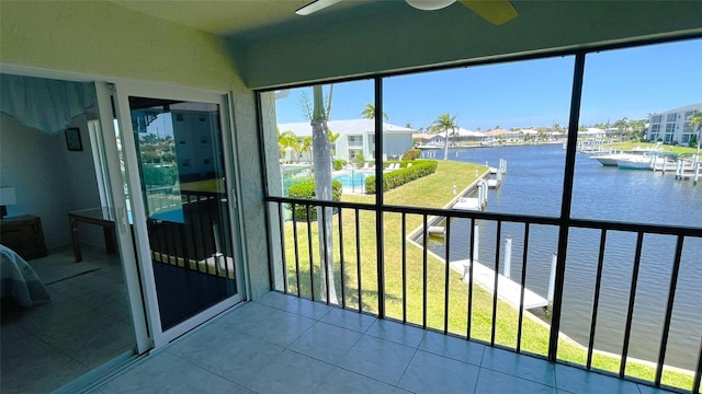 unfurnished sunroom featuring a water view and ceiling fan