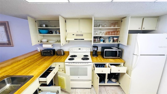 kitchen with sink, white appliances, a textured ceiling, and light tile patterned floors