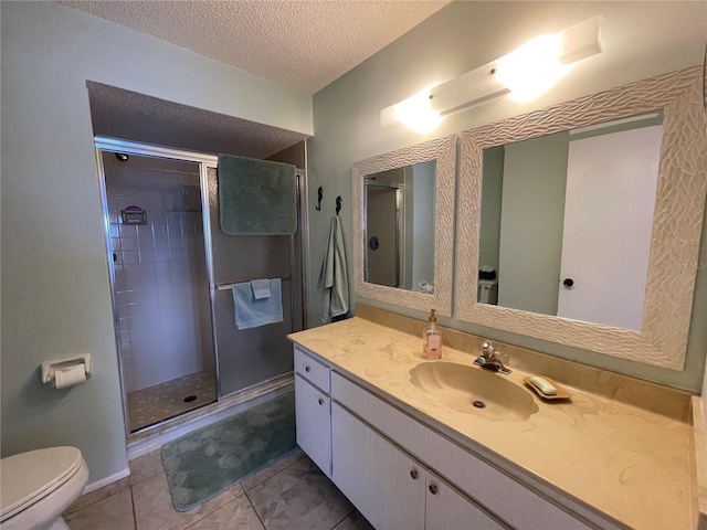 bathroom with toilet, a stall shower, a textured ceiling, and vanity