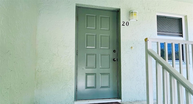 doorway to property featuring stucco siding