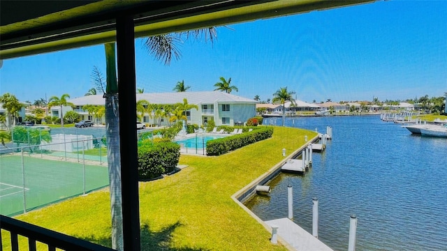 view of dock featuring a water view, a yard, and a community pool