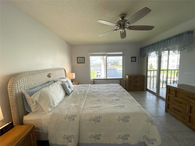 bedroom featuring access to exterior, ceiling fan, light tile patterned floors, and a textured ceiling