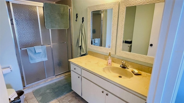 bathroom featuring tile patterned flooring, vanity, and walk in shower