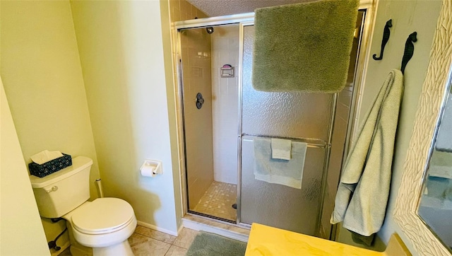 bathroom with tile patterned flooring, toilet, and a shower with shower door