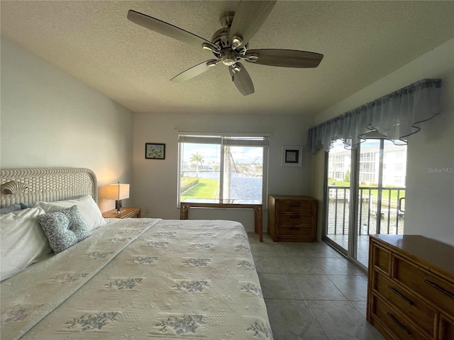 tiled bedroom featuring ceiling fan, access to exterior, and a textured ceiling