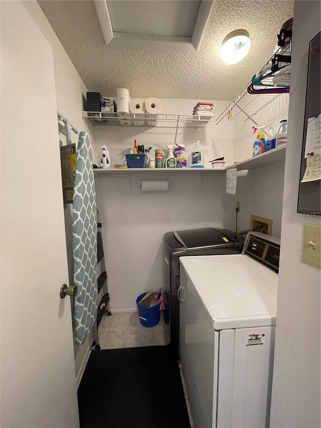 clothes washing area with a textured ceiling and washing machine and dryer