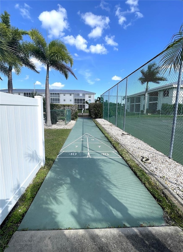 surrounding community with fence and shuffleboard