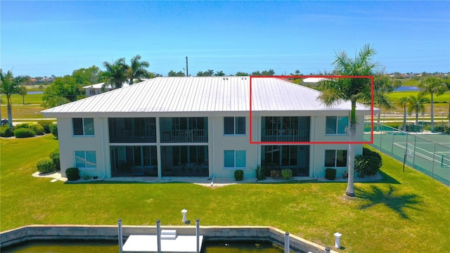 rear view of house featuring a lawn