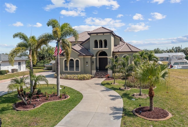 mediterranean / spanish-style house featuring a front yard