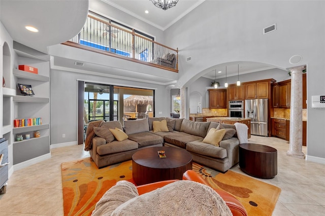 living room featuring high vaulted ceiling, decorative columns, light tile flooring, built in features, and crown molding