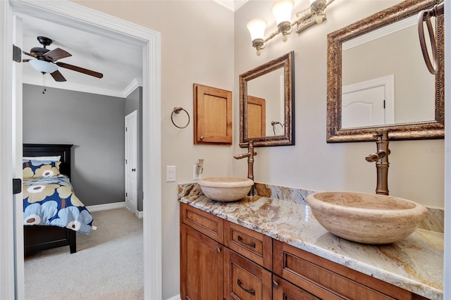 bathroom featuring large vanity, ceiling fan, crown molding, and double sink