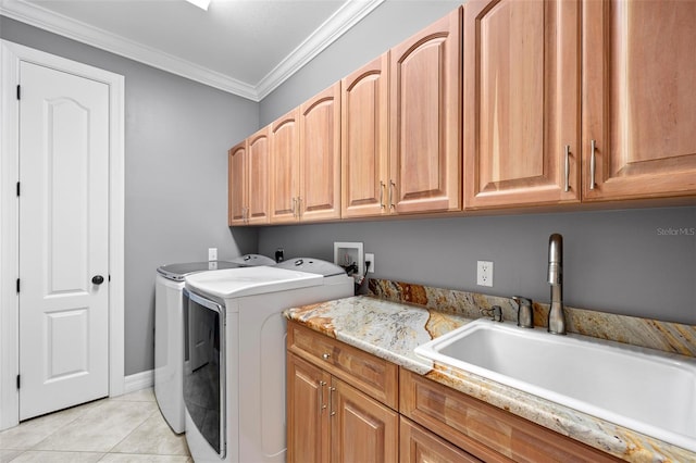 washroom featuring washing machine and dryer, cabinets, washer hookup, sink, and ornamental molding