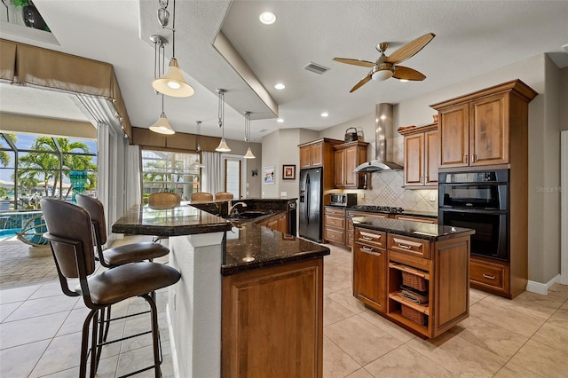 kitchen with a spacious island, light tile flooring, black appliances, tasteful backsplash, and wall chimney exhaust hood