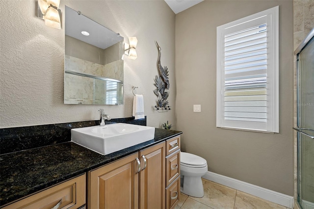 bathroom with large vanity, a shower with shower door, tile floors, and toilet