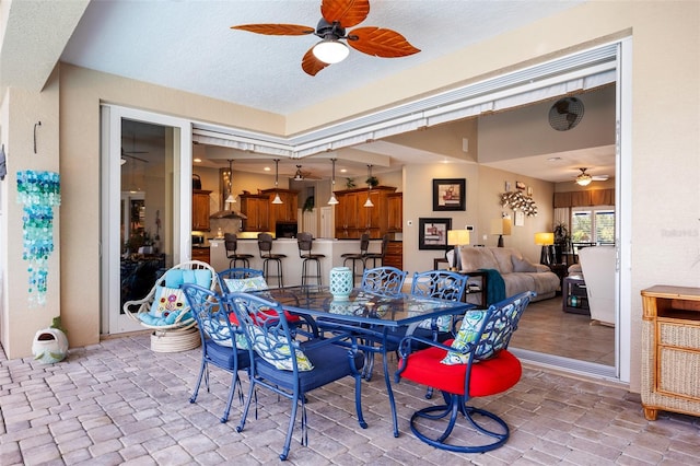 tiled dining space featuring ceiling fan and a textured ceiling