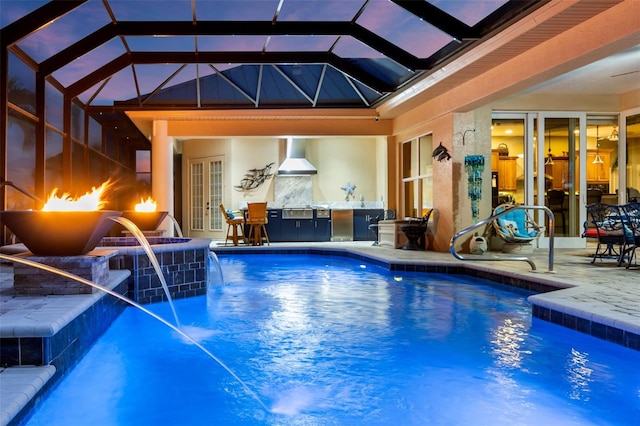 view of swimming pool featuring a patio, french doors, a lanai, pool water feature, and area for grilling