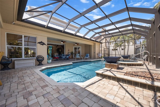 view of swimming pool with a patio area, ceiling fan, a lanai, a jacuzzi, and pool water feature