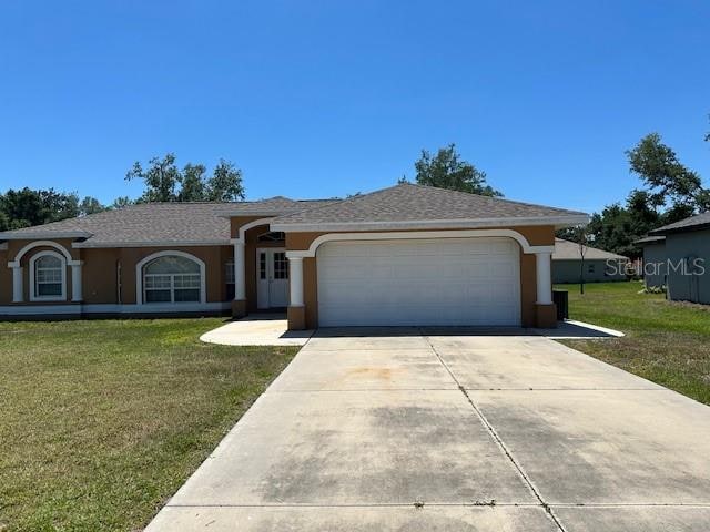 single story home featuring a garage and a front yard