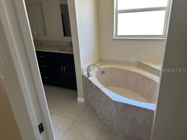 bathroom with tile flooring, vanity, and a tub